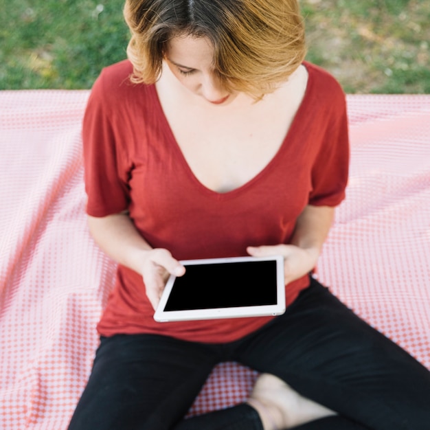 Foto gratuita desde arriba mujer usando tableta en el parque