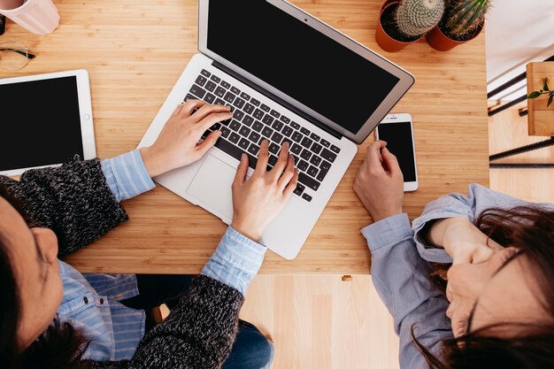 Desde arriba mujeres en la computadora portátil