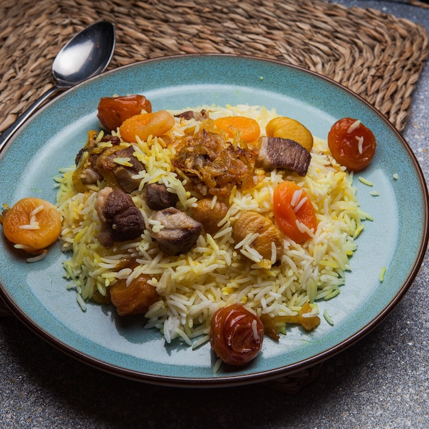 Desde arriba pilaf con frutas secas y secas y castañas y cuchara en plato redondo