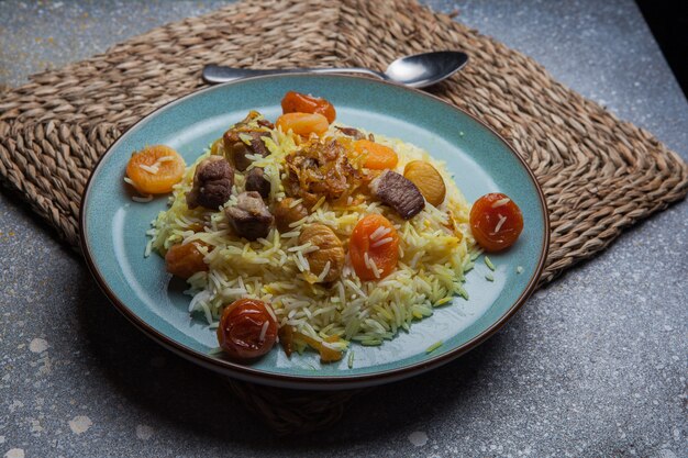 Desde arriba pilaf con frutas secas y secas y castañas y cuchara en plato redondo