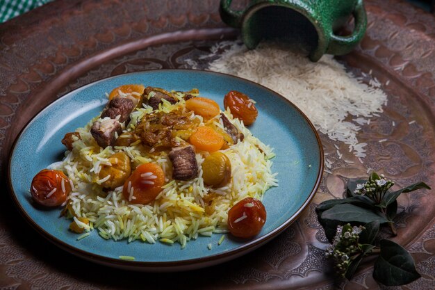 Desde arriba pilaf con frutos secos y secos y castañas y jarra en plato redondo