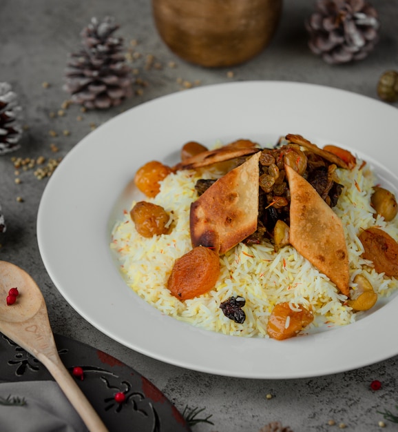 Foto gratuita arroz adorne con nueces y frutas secas dentro de un plato blanco.