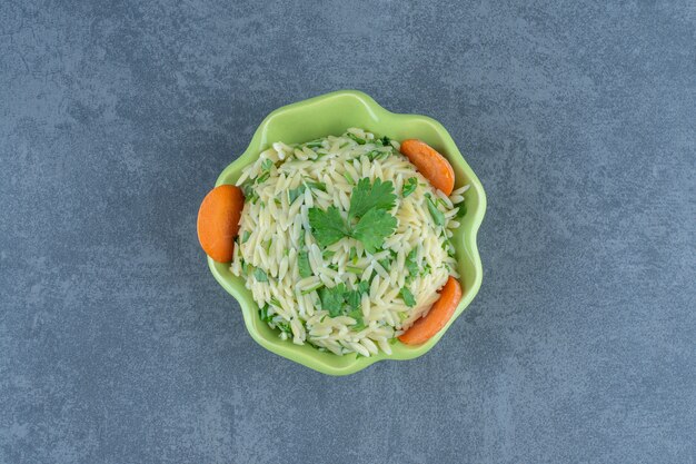 Arroz al vapor con verduras en un tazón verde.