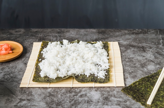 Arroz con algas sobre estera de sushi