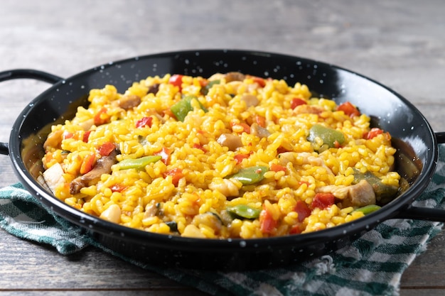 Foto gratuita arroz amarillo con pollo y verduras en una mesa de madera