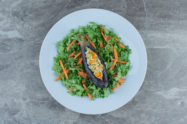 Arroz con berenjena en el plato de ensalada, sobre la mesa de mármol.