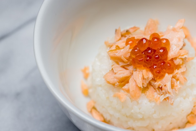 Arroz blanco con frutos de naranja en cuenco de cerámica blanca