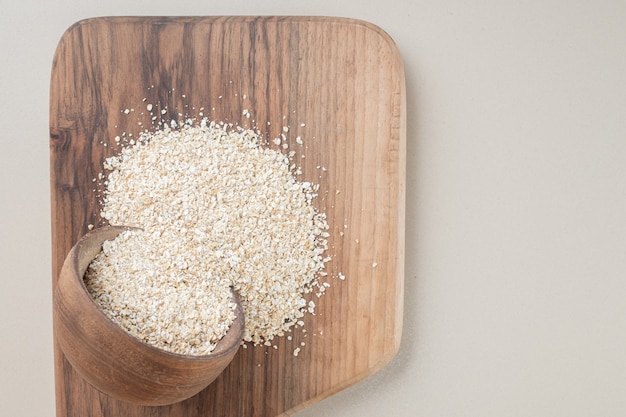 Arroz blanco en una taza de madera en el plato de madera.