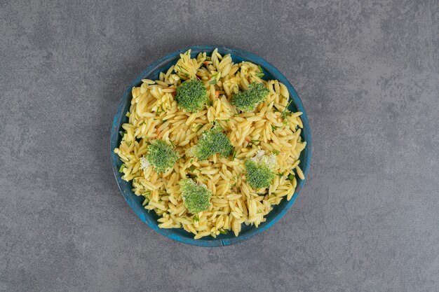 Arroz casero con brócoli en placa azul. Foto de alta calidad