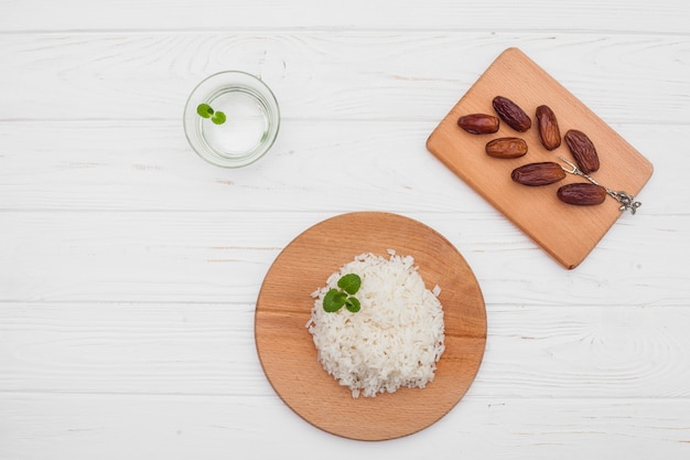 Arroz cocido con dátiles frutales en mesa de madera.