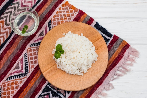 Arroz cocido sobre tabla de madera con agua.