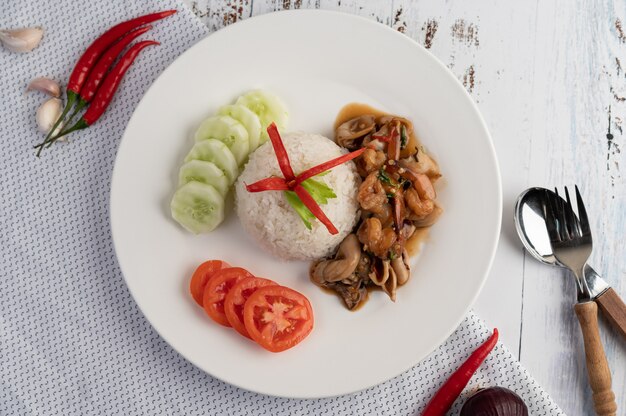 Arroz cubierto con albahaca salteada con calamares y camarones