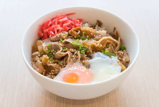 Arroz cubierto con rebanada de cerdo y huevo onsen