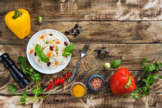 Arroz con frijoles vegetales y vegetales frescos y coloridos sobre una mesa de madera desgastada