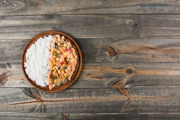 Arroz frito blanco y chino en plato de madera sobre la mesa