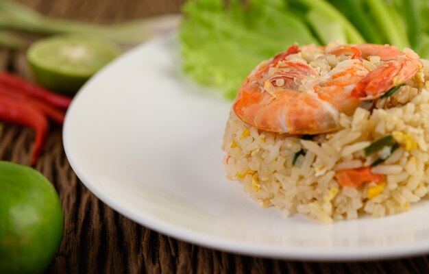 Foto gratuita arroz frito con camarones en un plato blanco sobre una mesa de madera