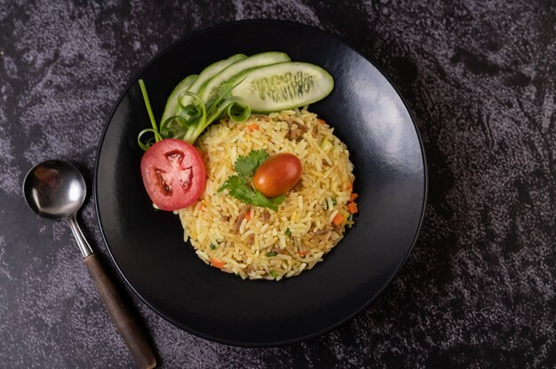 Arroz frito con carne de cerdo picada, tomate, zanahoria y pepino en el plato