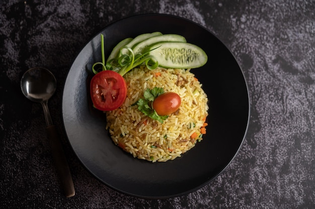 Arroz frito con carne de cerdo picada, tomate, zanahoria y pepino en el plato