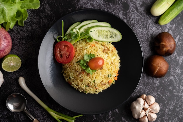 Arroz frito con carne de cerdo picada, tomate, zanahoria y pepino en el plato