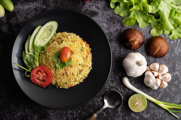 Arroz frito con carne de cerdo picada, tomate, zanahoria y pepino en el plato