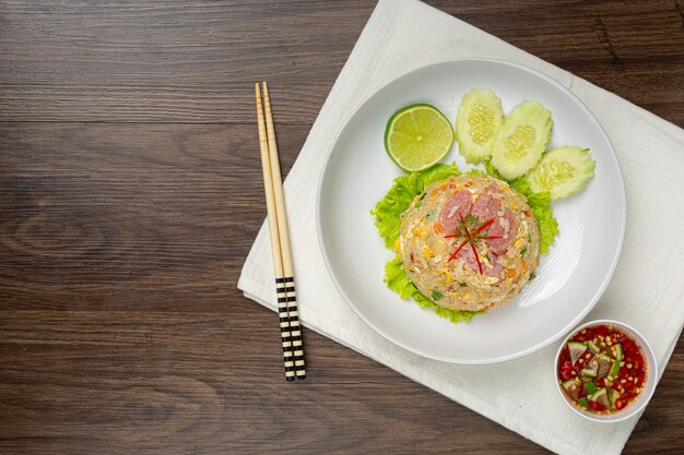 Arroz frito de cerdo fermentado servido con pepino fresco