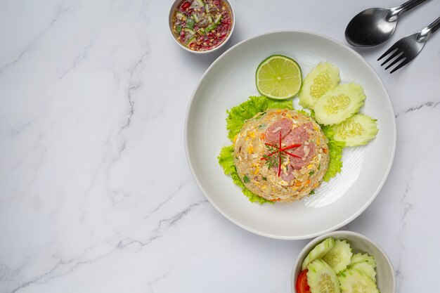 Arroz frito de cerdo fermentado servido con pepino fresco