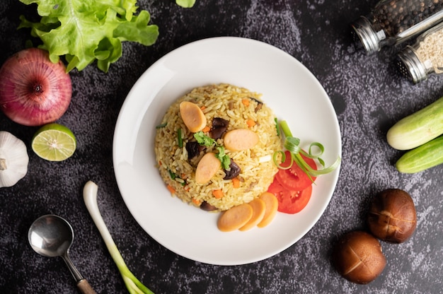 Arroz frito de salchicha con tomates, zanahorias y setas shiitake en el plato