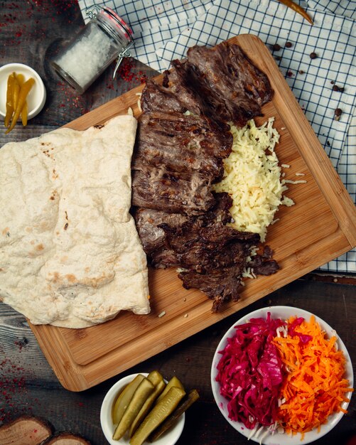 Arroz hervido con trozos de carne y encurtidos