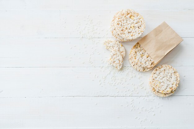 Arroz inflado hecho en casa con granos en tablón blanco de madera