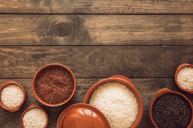 Arroz integral de jazmín integral; Arroz blanco y arroz orgánico en un tazón en la mesa de madera