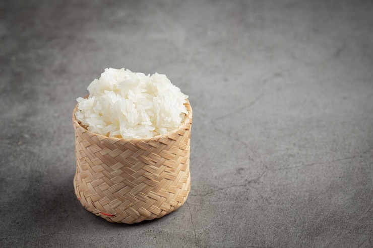 Foto gratuito arroz pegajoso en canasta de bambú puesto en piso oscuro
