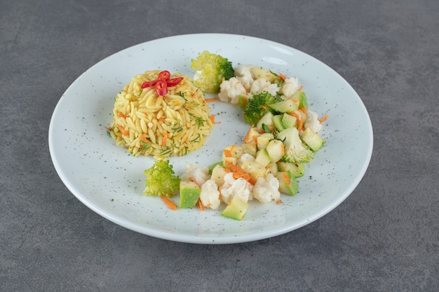 Arroz sabroso y verduras saludables en un plato blanco. Foto de alta calidad