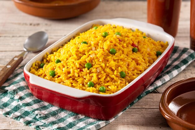 Arroz tradicional mexicano servido con guisantes en mesa de madera