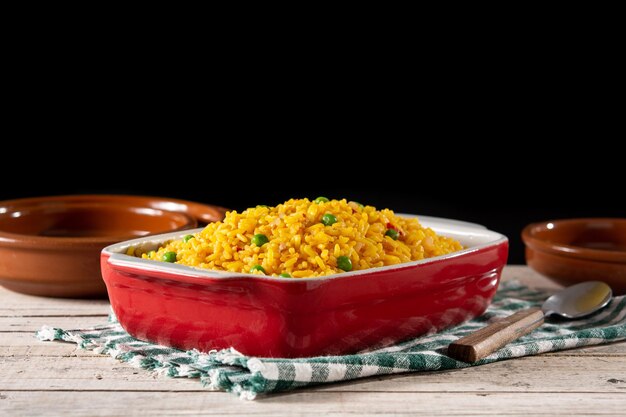 Arroz tradicional mexicano servido con guisantes verdes en mesa de madera