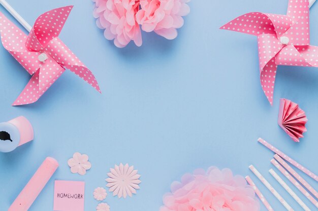 Arte y equipo rosados del arte del origami dispuestos en marco circular en fondo azul