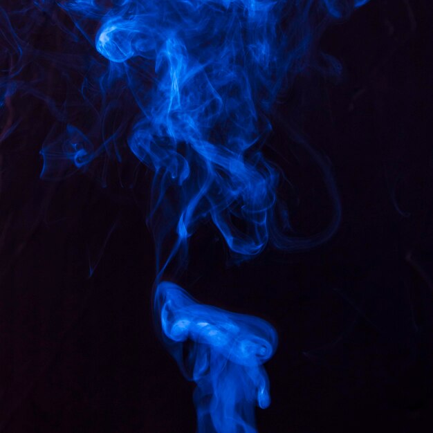 Arte del humo azul brillante que se mueve hacia arriba sobre fondo negro