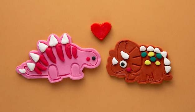 Foto gratuita arte de plastilina con dinosaurios y corazón rojo.