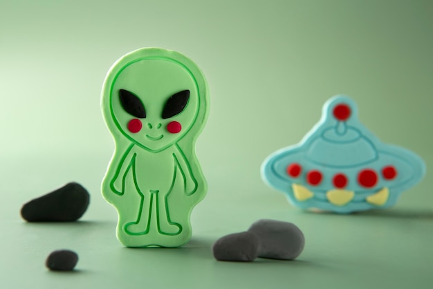 Arte de plastilina con extraterrestre y nave espacial.