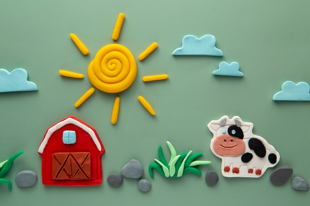 Foto gratuita arte de plastilina con vaca y granero