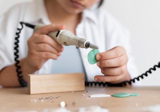 Artesana trabajando en el atelier con pistola de pegamento