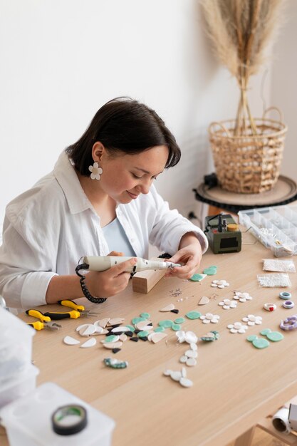 Artesana trabajando en el atelier con pistola de pegamento