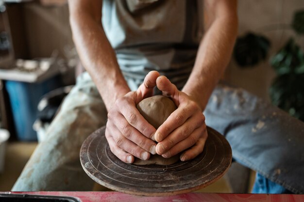 Artesano de alto ángulo haciendo cerámica en estudio.