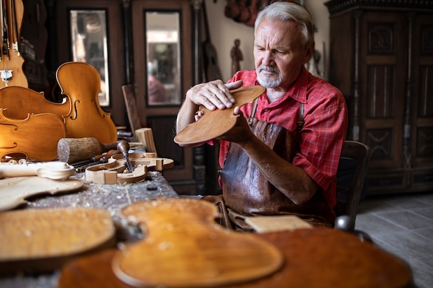 Foto gratuita artesano carpintero senior comprobar la calidad del producto de madera