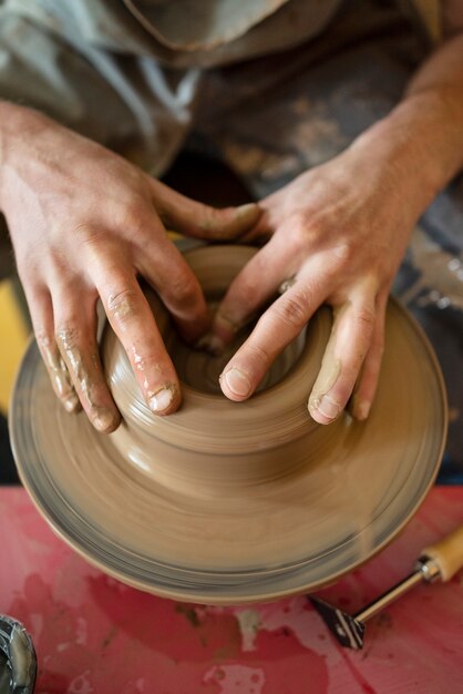 Artesano haciendo cerámica en ángulo alto de estudio