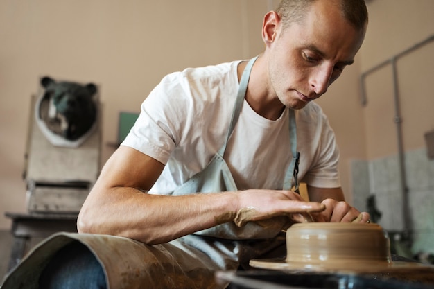 Foto gratuita artesano haciendo cerámica en ángulo bajo de estudio