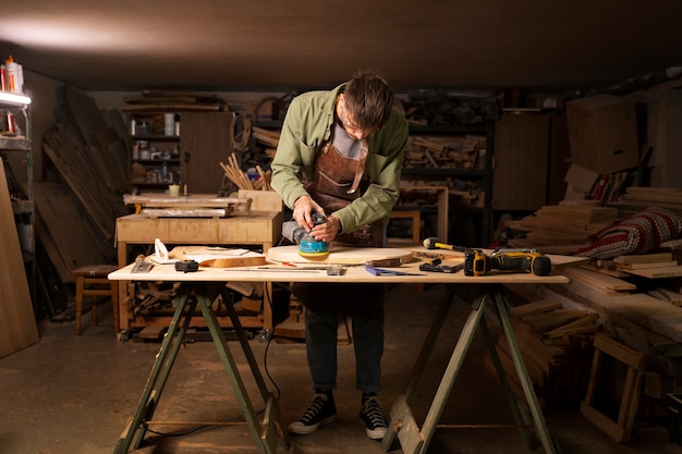 Foto gratuita artesano de tiro completo haciendo tala de madera.