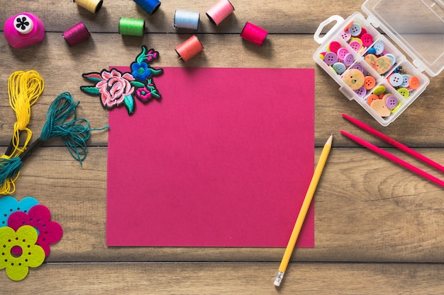 Artículos de artesanía y tarjeta decorativa en blanco sobre fondo de madera