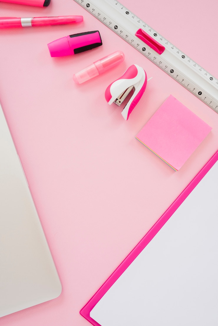 Foto gratuito artículos de color rosa de alto ángulo en el escritorio