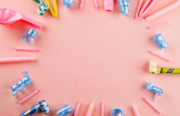 Artículos de fiesta coloridos en una mesa de color rosa.