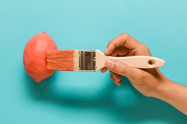 Foto gratuita artista anónimo pintando limon en color rosa